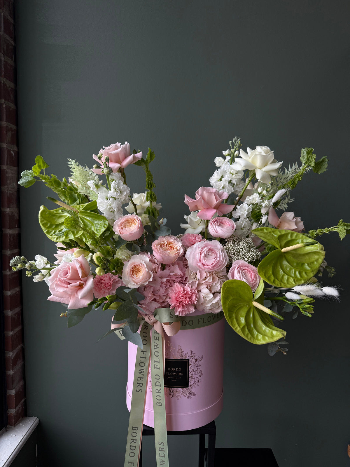 "Most Wanted" arrangement: large-size signature design with white & pink blooms and exotic green anthurium. Wet floral sponge included. Dallas delivery.