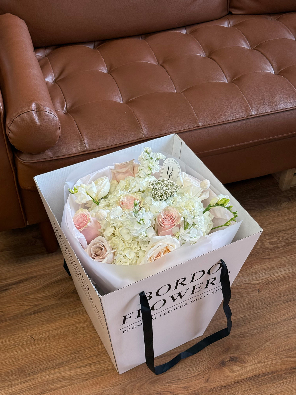 “Love Letter” floral arrangement wrapped with blush ribbon